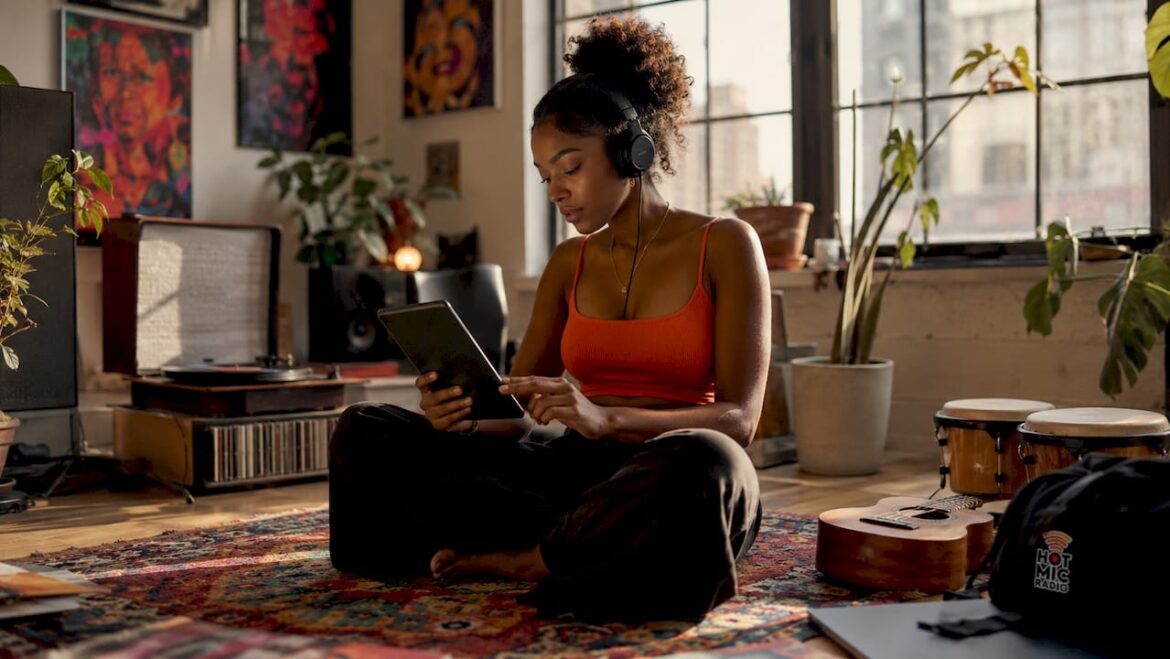 Woman curating hip hop playlist with headphones on