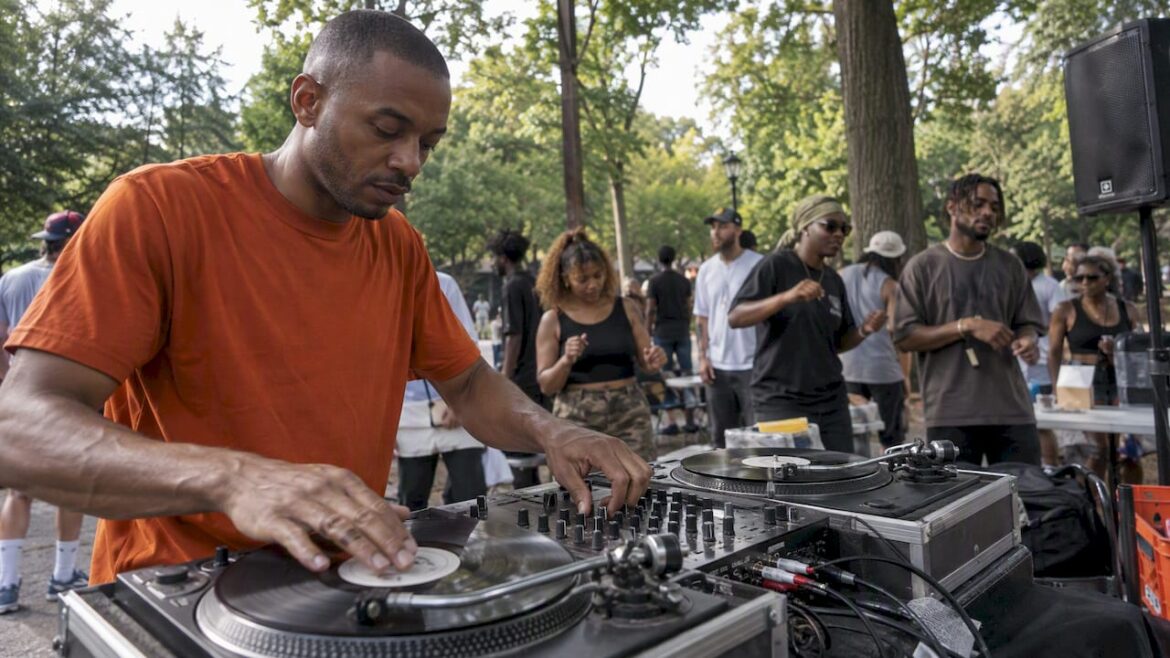 Hip-hop DJ mixing records at a park jam